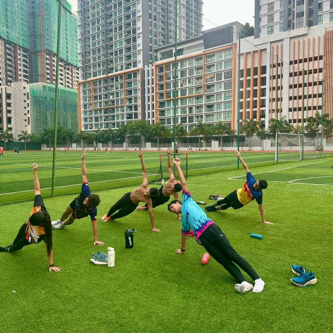 The squad holding a stretch in a line across the grass