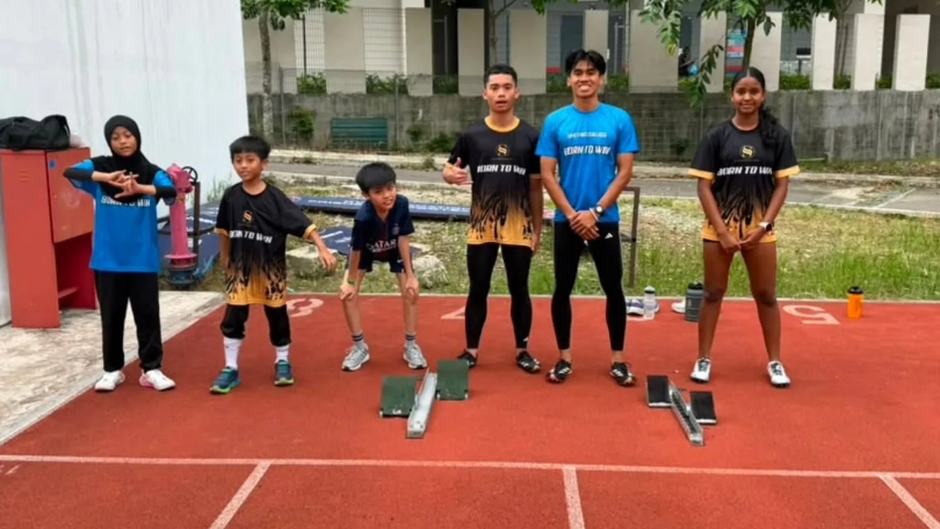 Athletes setting up over starting blocks on the track
