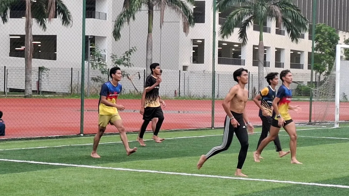 Runners mid-stride during a session on the grass